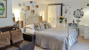 Une chambre à coucher comprenant un lit, un canapé en cuir, une commode et une table de chevet.