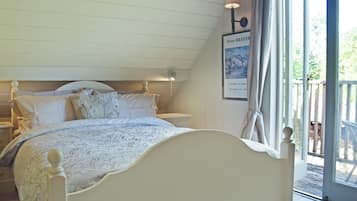A bedroom with a bed, a nightstand, a wall-mounted lamp, and a poster.