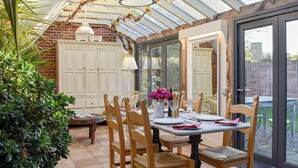 A conservatory with a dining table set for four, surrounded by wooden chairs. - 2 bedroom accommodation in Ilketshall St. Margaret, near Bungay (Ilketshall St. Margaret, near Bungay)