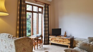 Un salon avec une table basse en bois, un téléviseur et un canapé.