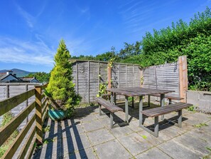 A wooden deck with picnic tables and a green potted plant. - 5 bedroom accommodation in Keswick (Keswick)