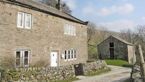 A stone building with a gravel driveway, a stone wall, and a small garden area. - 4 bedroom accommodation in Halton Gill, near Litton (Halton Gill, near Litton)