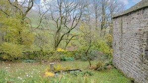 A garden with a stone wall, various plants, and a small pond. - 4 bedroom accommodation in Halton Gill, near Litton (Halton Gill, near Litton)