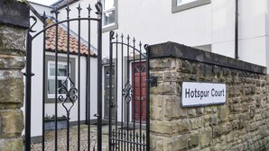 Un muro de piedra con un letrero que dice Hotspur Court.