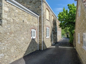 A narrow stone street flanked by traditional buildings with small windows and a clear sky. - 3 bedroom accommodation in Spring Gardens, Frome (Spring Gardens, Frome)