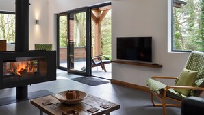 Ein modernes Wohnzimmer mit Kamin, Fernseher und einer gemütlichen Sitzecke.