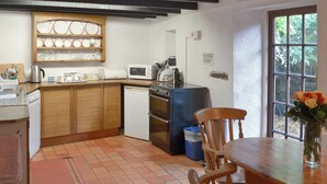 Eine kleine Küche mit Holzausstattung, einer Mikrowelle, einem Toaster und einem Spülbecken.