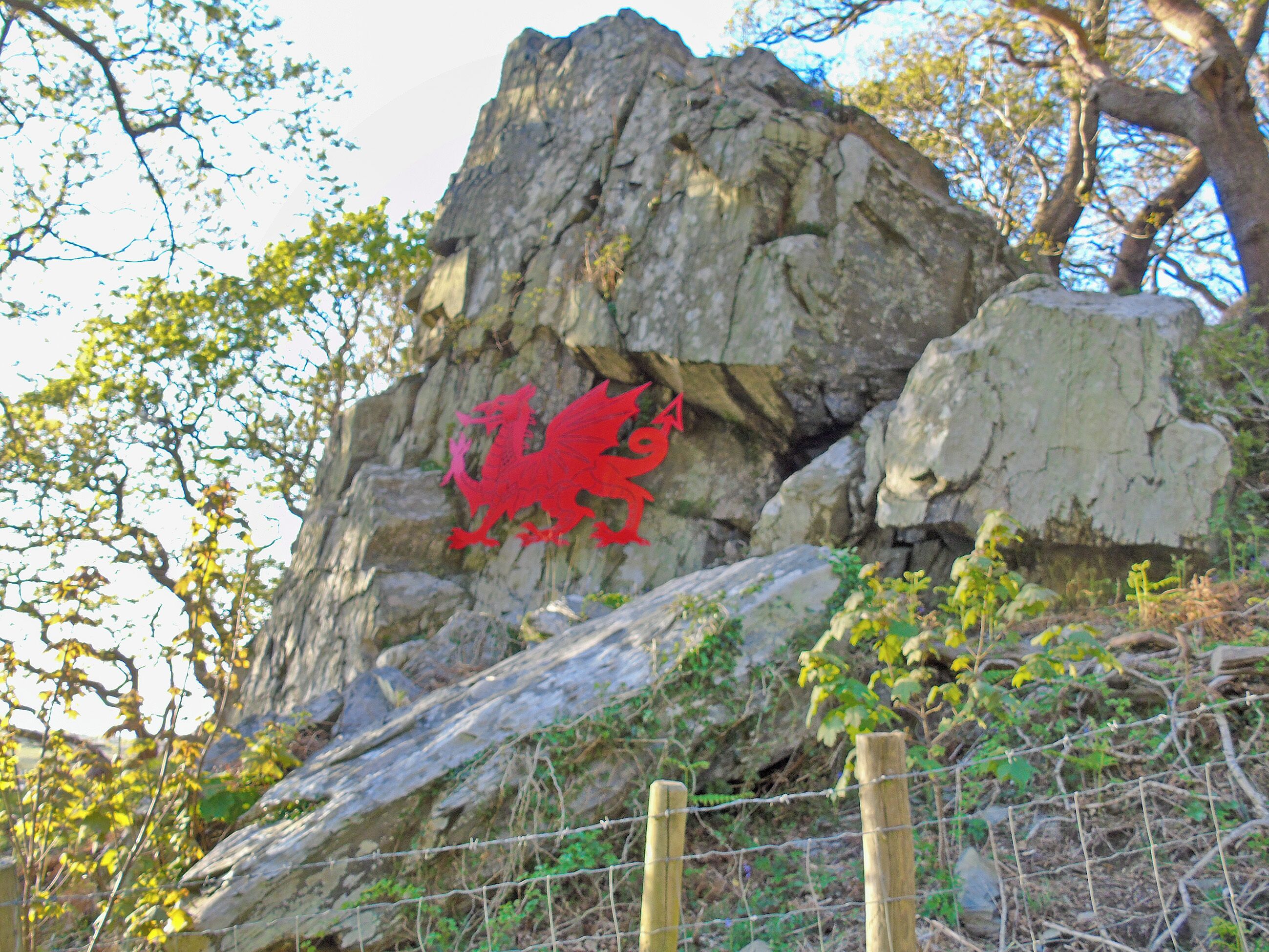 A rock formation with a red dragon symbol.