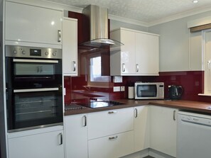 A modern kitchen with built-in appliances, including a double oven, microwave, and dishwasher. - 4 bedroom accommodation in Carrbridge (Carrbridge)