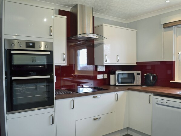 A modern kitchen with built-in appliances, including a double oven, microwave, and dishwasher.