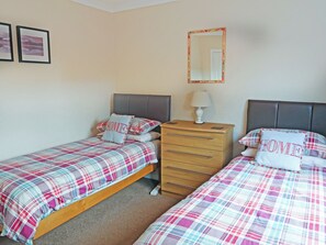 A bedroom with two beds, a dresser, a mirror, and two framed pictures on the wall. - 4 bedroom accommodation in Carrbridge (Carrbridge)