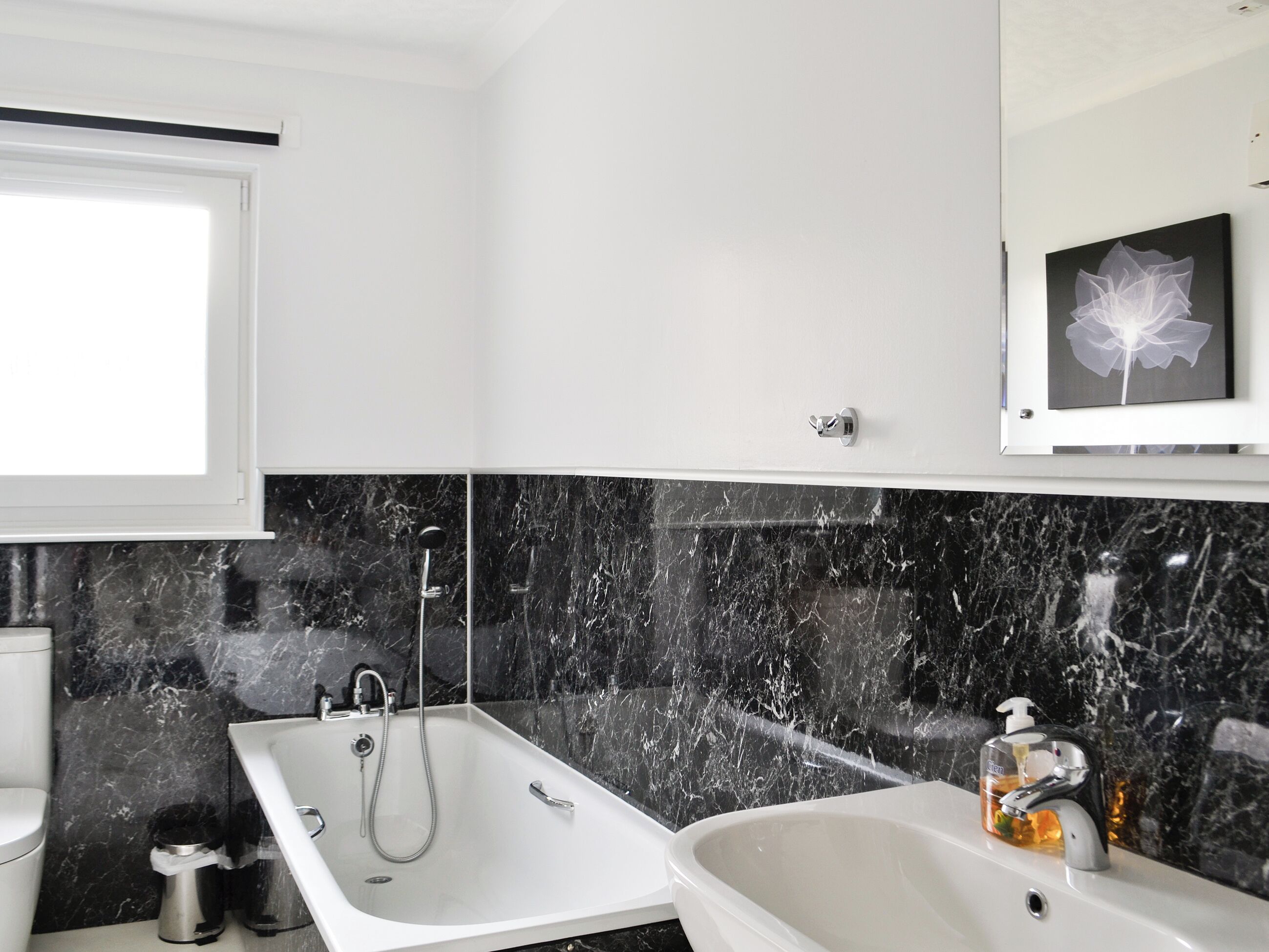A bathroom with a bathtub, a shower, a toilet, and a sink.