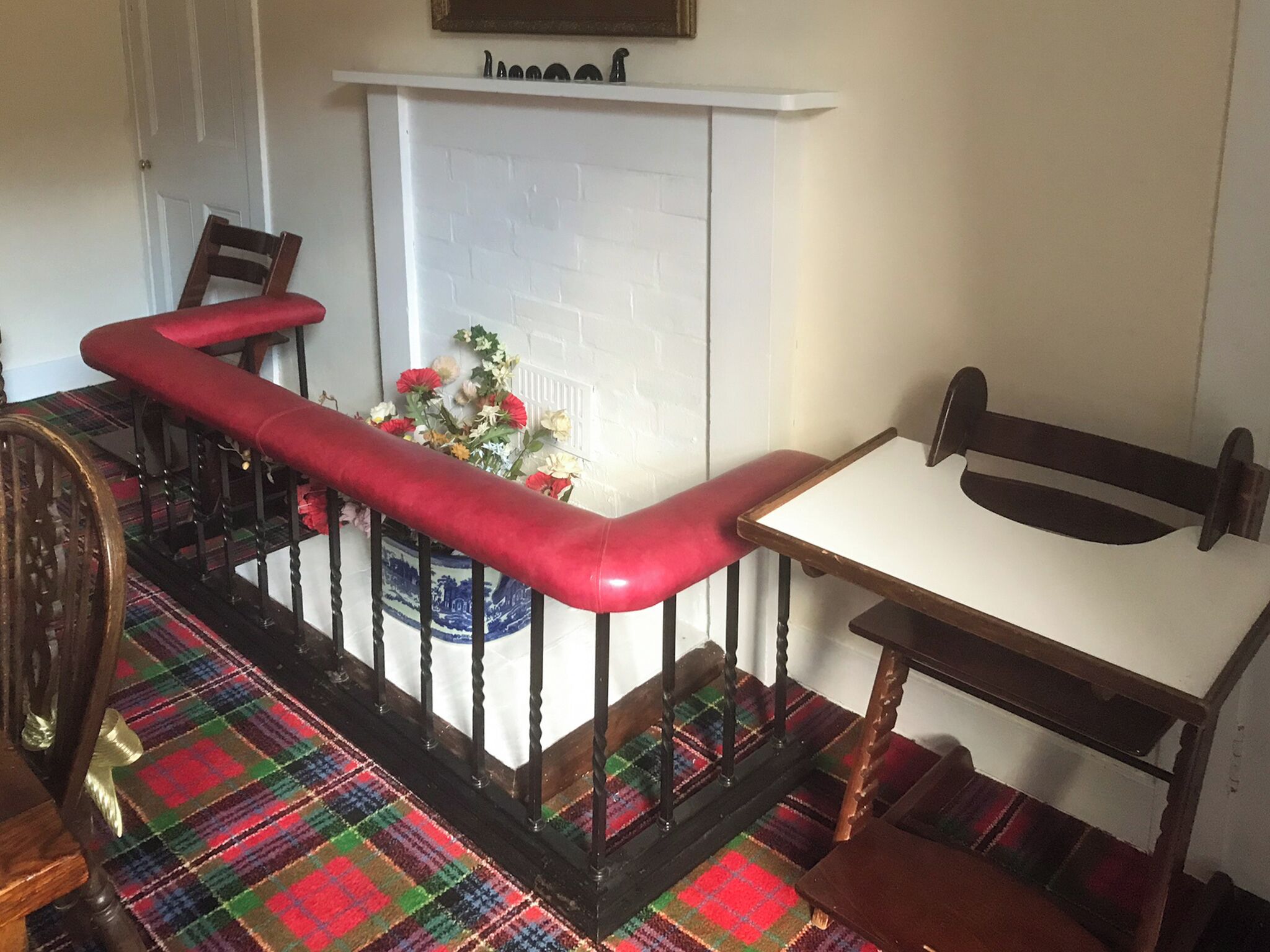 Ein Zimmer mit Treppe, Kamin, Tisch und Stühlen.