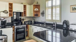 Una cucina moderna con isola centrale, forno integrato ed elettrodomestici in acciaio inossidabile.
