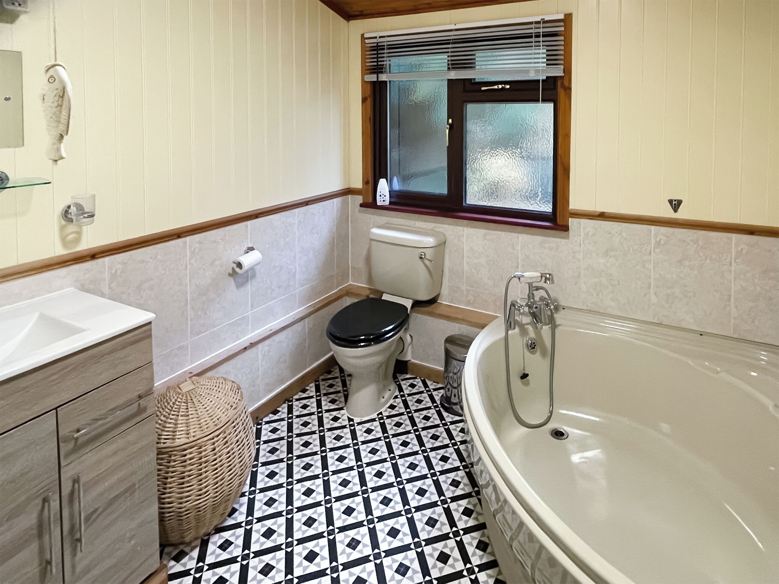 Een badkamer met toilet, wastafel en bad.