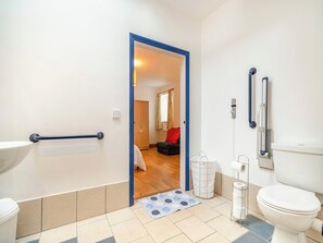 Une salle de bain comprenant des toilettes, un bidet et un espace douche.