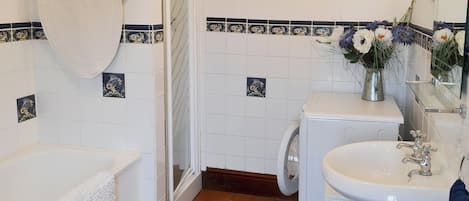 A bathroom with a bathtub, a toilet, and a sink.