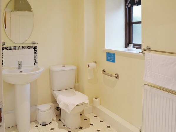 A bathroom with a toilet, sink, and a window. - 1 bedroom accommodation in High Halstow, near Rochester (High Halstow, near Rochester)