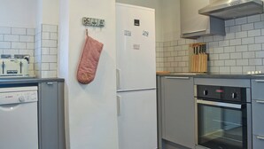 Een praktische keuken met een Bosch vaatwasser, een koelkast en een Cera oven.