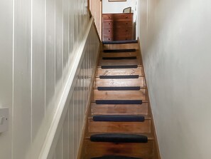 Eine Holztreppe mit Handlauf und ein Holzschrank im Hintergrund.