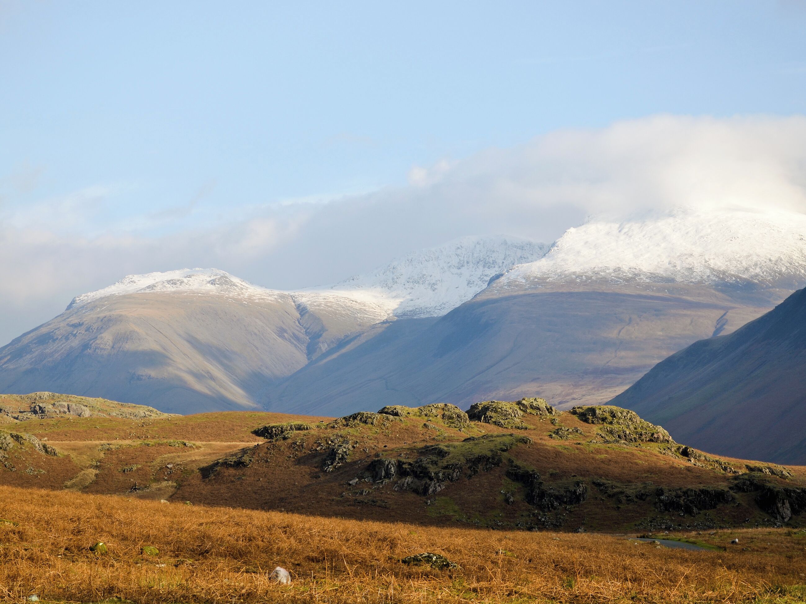 A mountainous landscape with a valley and a small stream.