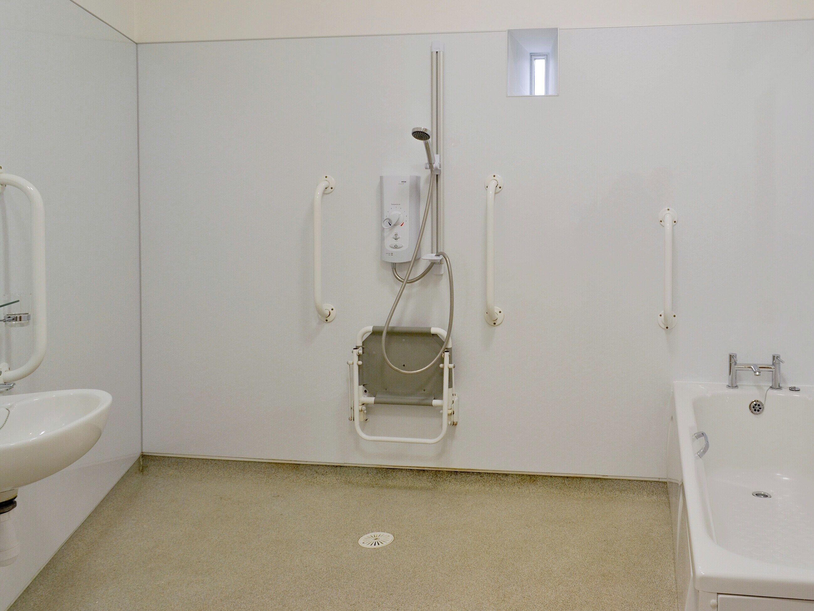 A bathroom with a shower, a sink, and a toilet.