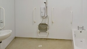 Een badkamer met een douche, wastafel en toilet.