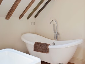 A modern bathroom with a freestanding bathtub, a showerhead, and a towel. - 2 bedroom accommodation in Aldbrough, near Hornsea (Aldbrough, near Hornsea)