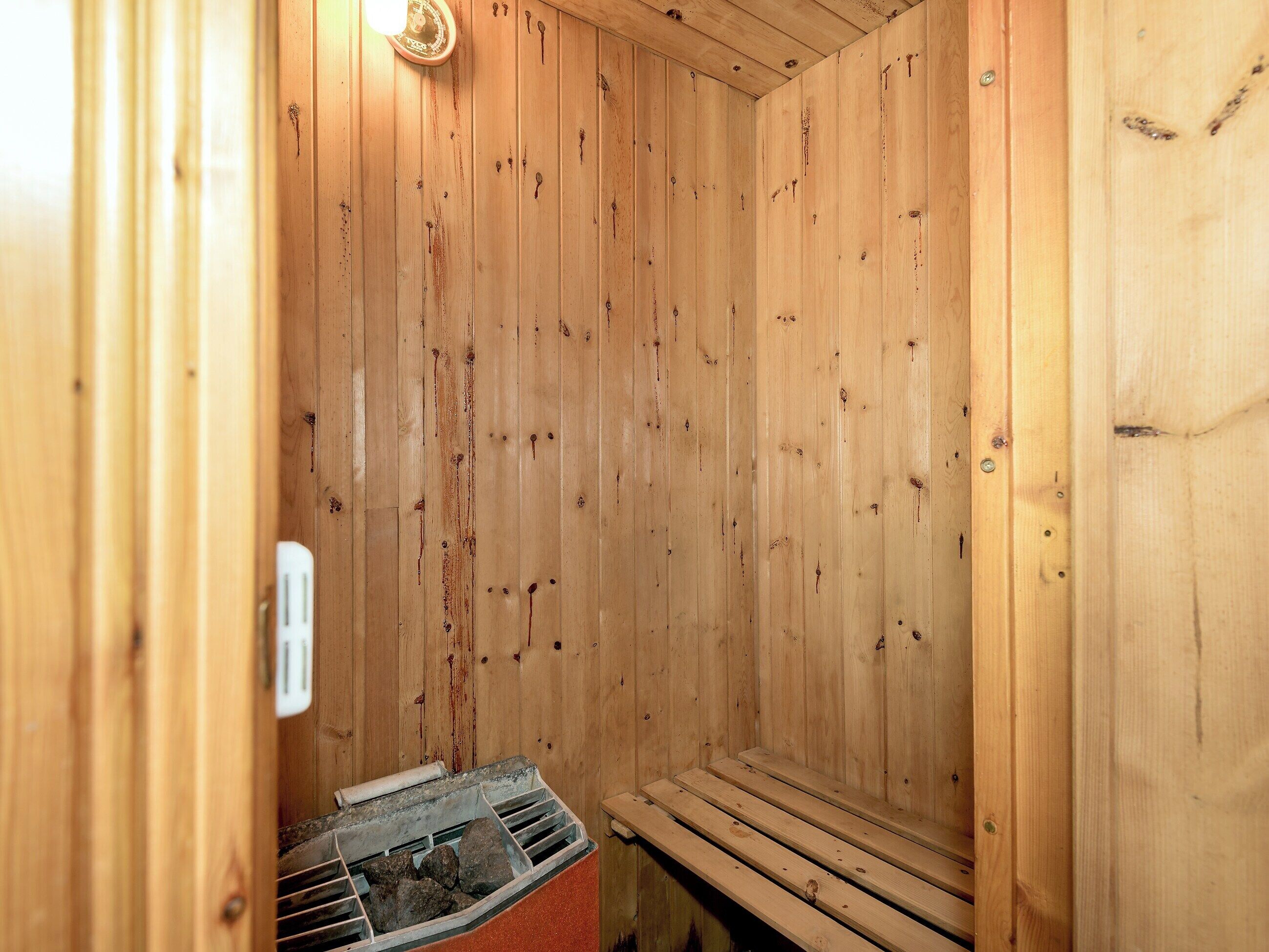 A sauna with wooden walls, benches, and a visible heater.