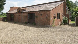 A brick building with a tiled roof, a front door, and a gravel driveway. - 4 bedroom accommodation in Necton, near Swaffham (Necton, near Swaffham)
