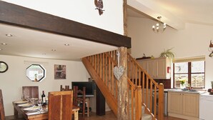 A spacious kitchen with a wooden staircase, a dining area with chairs and a table, and a view of the outside through a window. - 4 bedroom accommodation in Necton, near Swaffham (Necton, near Swaffham)