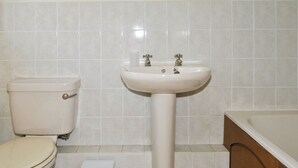 Un baño con inodoro, lavabo y espejo.