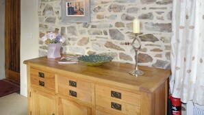 Un aparador de madera con cajones, un cuadro enmarco, un candelabro y un cuenco decorativo.