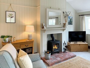 A living room with a fireplace, television, and a cozy sofa.