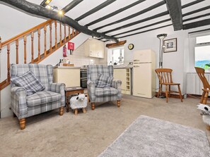 A cozy living room with a staircase, a kitchen area, and a dining area. - 2 bedroom accommodation in Bassenthwaite, near Keswick (Bassenthwaite, near Keswick)
