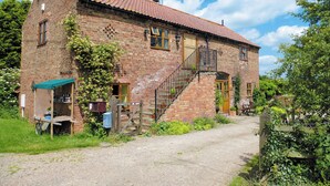 A brick building with a red-tiled roof, a wooden staircase, and a gravel driveway. - 2 bedroom accommodation in Gringley-on-the-Hill (Gringley-on-the-Hill)