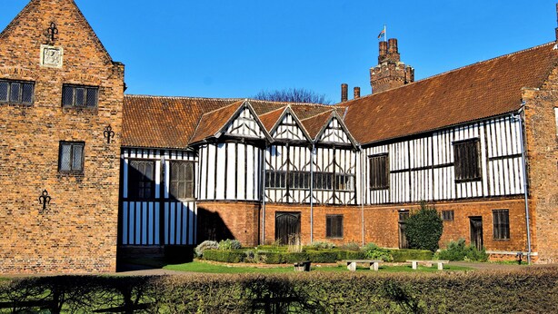 A historic building with a prominent tower and a courtyard with benches and a well-maintained garden. - 2 bedroom accommodation in Gringley-on-the-Hill (Gringley-on-the-Hill)