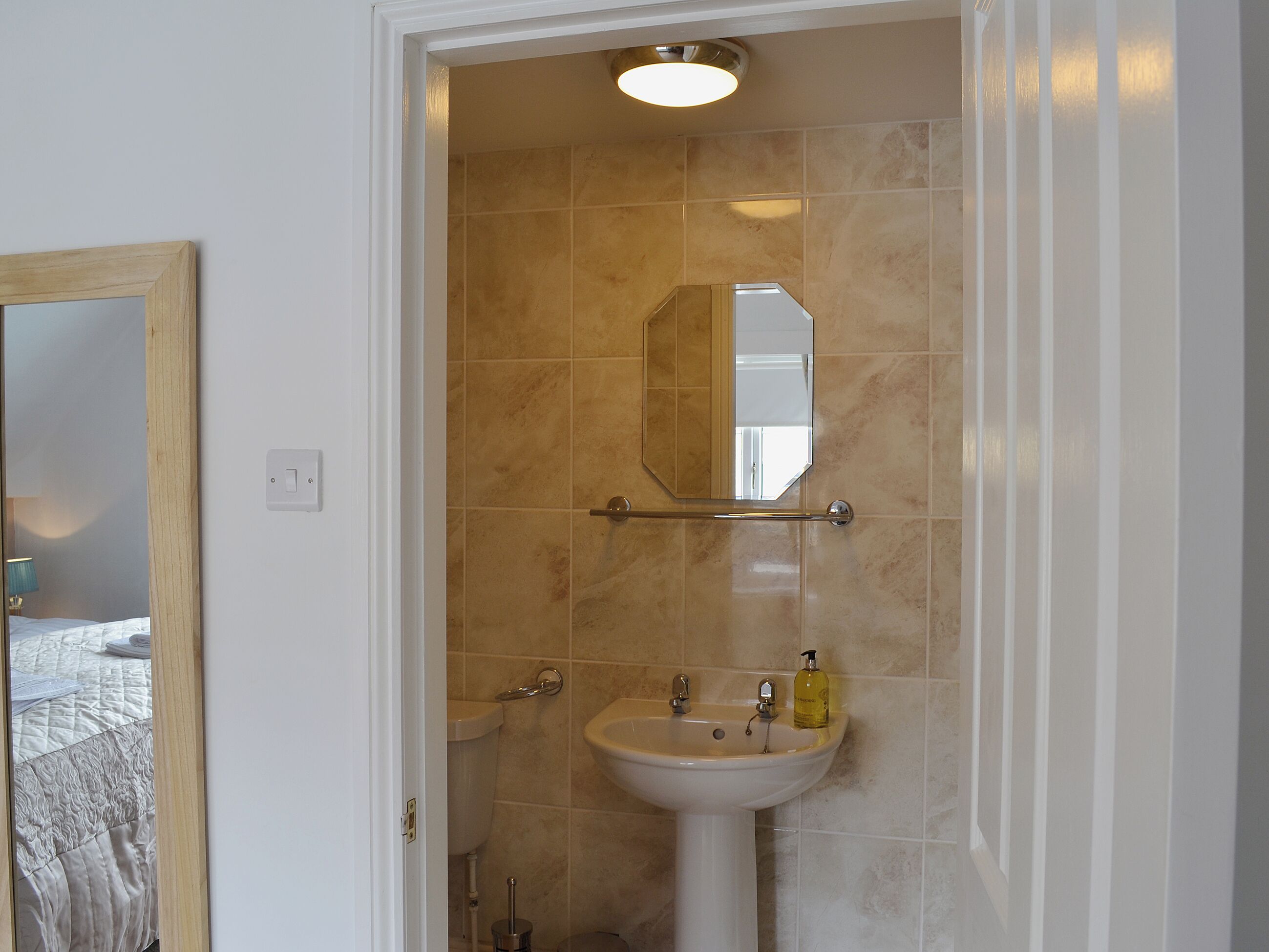 A bathroom with a sink, mirror, and towel rack.