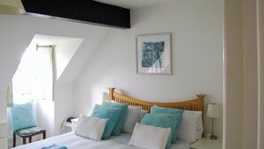 A bedroom with a bed, pillows, a bedside table, a lamp, a chair, and a window. - 2 bedroom accommodation in Island Harbour, near Newport (Island Harbour, near Newport)