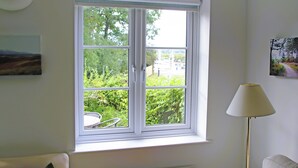 A room with a large window, a radiator, a floor lamp, and a painting on the wall. - 2 bedroom accommodation in Island Harbour, near Newport (Island Harbour, near Newport)