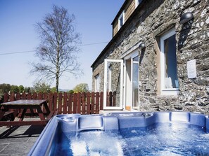 A stone building with a wooden deck and a hot tub. - 2 bedroom accommodation in Kirkcudbright (Kirkcudbright)