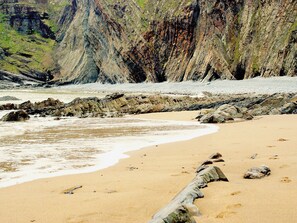 A beach with a rocky shoreline and cliffs in the background. - Heale Cottage - 28087 (Littleham, near Bideford)