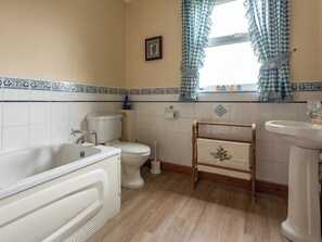 A bathroom with a bathtub, toilet, sink, and wooden stool. - 3 bedroom accommodation in Newcastleton (Newcastleton)