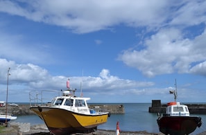 A harbor with boats docked, a pier, and a clear sky.