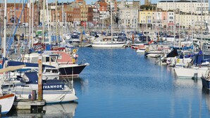 A marina with numerous boats docked, surrounded by buildings and a clear sky. - 1 bedroom accommodation in Ramsgate (Ramsgate)