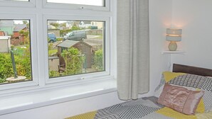 Una camera da letto con un letto, una finestra, una lampada e vista sull'esterno.