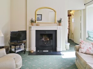 A living room with a fireplace, a television, and a sofa.