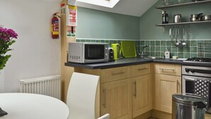 A compact kitchen with a skylight, a microwave, a kettle, and a sink. - 1 bedroom accommodation in York (York)