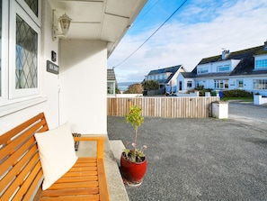 A wooden bench outside a building with a potted plant nearby. - 2 bedroom accommodation in Port Isaac (Port Isaac)