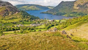 A scenic landscape with a lake, rolling hills, and a small village. - 3 bedroom accommodation in Helton (Helton)